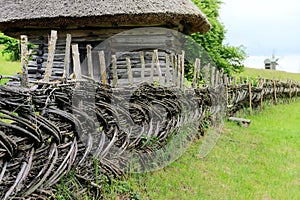 Rustic fence in village near the house near the forest. Authentic traditional culture in architecture and life. Old wooden