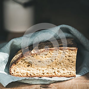 Rustic French rye bread loaf on wooden board, square crop
