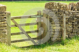 Rustic gate in drystone wall in Bibury England UK.