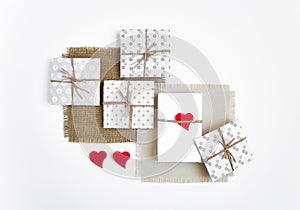 Rustic handmade gift boxes on white background decorated with hearts. Top view, flat lay
