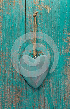 Rustic heart on turquoise wooden surface for valentine, birthday