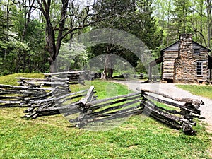 Rustic historic log cabin with wooden fence