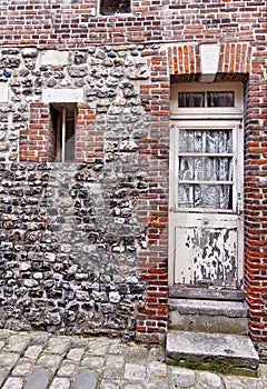 Rustic house facade with white exterior doors in Honfleur, France