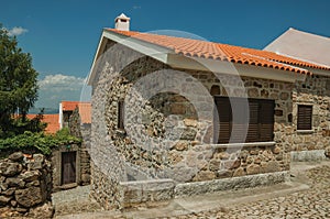 Rustic house with stone wall on cobblestone alley