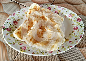 Rustic indian roti paratha fried pancake on wooden table