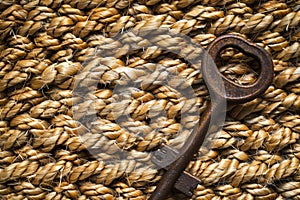 rustic iron key on woven jute doormat