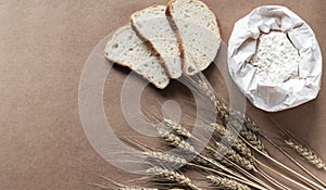 Rustic kitchen or bakery background with flour, bread and wheat spikelets