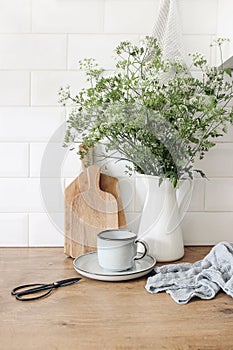 Rustic kitchen interior. Still life composition with cup of coffee, wooden chopping boards and cow parsley bouquet in