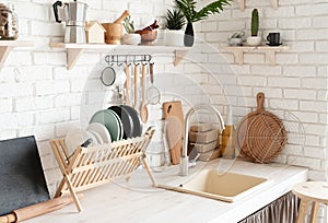 Rustic kitchen interior with white brick wall and white wooden shelves