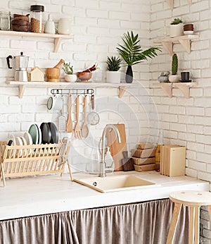 Rustic kitchen interior with white brick wall and white wooden shelves