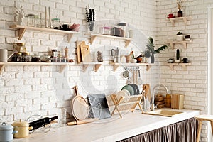 Rustic kitchen interior with white brick wall and white wooden shelves