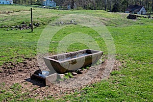 Rustic long stone farm animal water trough salt lick in village scene