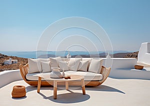 Rustic lounge sofa and coffee table on white stone terrace. Traditional mediterranean architecture. Summer background with sea