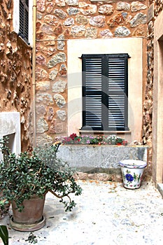 Rustic Mediterranean patio with flowerpots and shutters