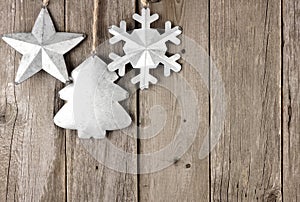 Rustic metal Christmas ornaments hanging on aged wood