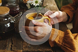 Rustic morning breakfast. Person drinking tea with lemon slice.