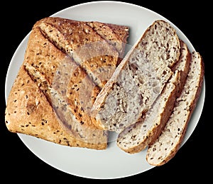 Rustic Multigrain Bread Sliced Loaf on White Ceramic Platter Isolated on Black Background