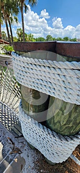 Rustic nautical rope fence and wrapped wooden dock posts. Vacation resort paradise.