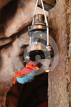 Rustic oil lamp with toy bird hanging at the bottom