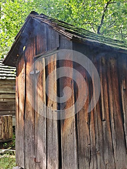 Rustic Old Meat Smokehouse with Smoke Leaking Out