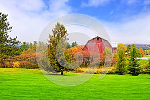 Rustic old red barn during autumn with colorful fall leaves