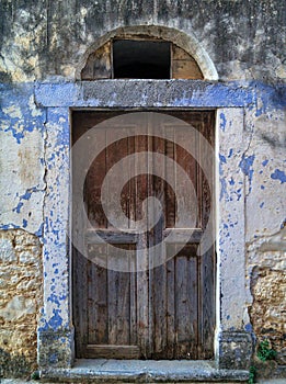 Rustic old wooden door on colorful wall.