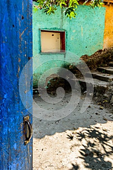 Rustic open blue door & turquoise & yellow wall