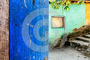 Rustic open blue door & turquoise & yellow wall