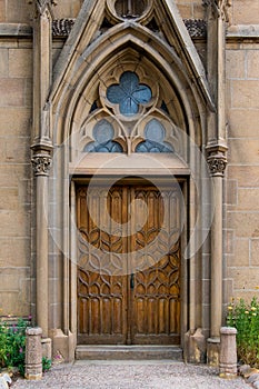 Rustic ornate wood door in a Gothic architecture facade of an old church