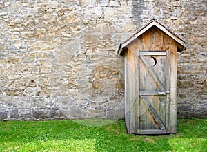 Rustic outhouse and vintage stone wall