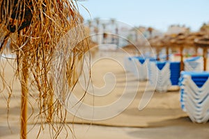 rustic parasols and sunloungers on a lonely beach