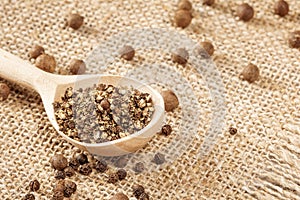 Rustic pepper grinder with freshly ground pepper on a traditional farmer's cloth napkin