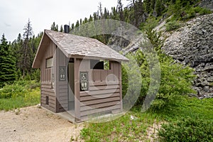 Rustic pit toilet bathrooms outdoors with one stall and handicap access photo