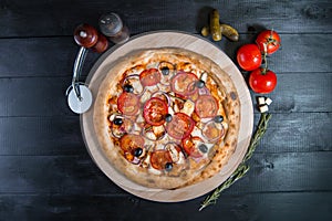 Rustic pizza with salami, mozzarella, fresh tomatoes, red onion, black olives and fresh basil. Home made pizza