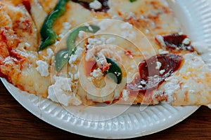 Rustic pizza with salami, mozzarella, olives and basil top view with copy space.