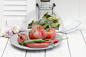 Rustic Plate With Red Tomatoes And Hot Chilly Across White Kitchen Area