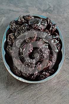 Rustic plate with tasty smoked dried plums on table