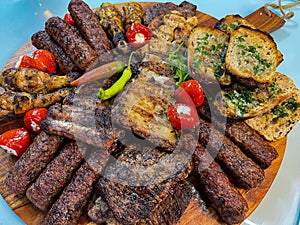 Rustic platter prepared for tourists with mici, pork neck on wooden platter