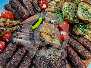 Rustic platter prepared for tourists with mici, pork neck on wooden platter