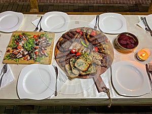 Rustic platter prepared for tourists with mici, pork neck on wooden platter
