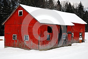 A rustic red barn in snow