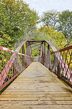 Rustic Red Pedestrian Bridge in Autumn Park - Eye-Level View