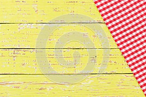 Rustic red picnic tablecloth on old wooden table top background