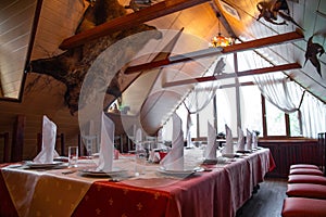 Rustic restaurant interior with hunting theme and long table set for banquet