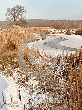 A rustic river covered with ice winds through a small village