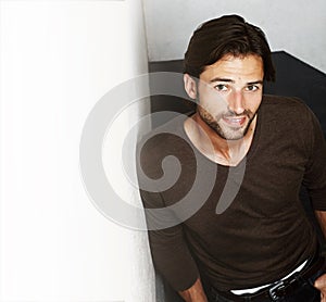 Rustic and rugged. Portrait of a handsome young man leaning against a wall.