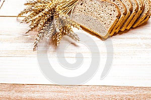 Rustic rye. Fresh loaf of rustic traditional bread with wheat grain ear or spike plant on wooden texture background. Bakery with