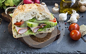 Rustic sandwich with ham,fresh bread,salad,tomatoes and cucumber