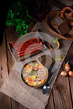 A rustic sauerkraut soup with bacon and sausage