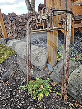 a group of rusted pipes next to a pile of logs